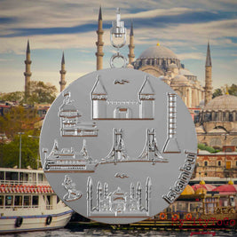 Halskette mit Drehwirbel und Vorderseite eines silbernen Schmuckanhängers, auf dem Reliefs bekannter Sehenswürdigkeiten der Stadt Istanbul abgebildet sind. Den Hintergrund bildet eine Ansicht der Stadt Istanbul.
