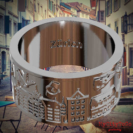 Versilberter Ring mit Reliefs bekannter Sehenswürdigkeiten der Stadt Zuerich und einer Gravur des Stadtnamens auf der Innenseite. Den Hintergrund bildet eine Ansicht der Stadt Zuerich.