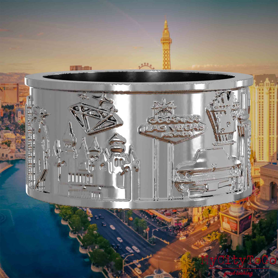 Silberner Ring mit Reliefs bekannter Sehenswürdigkeiten der Stadt Las Vegas. Den Hintergrund bildet eine Ansicht der Stadt Las Vegas.