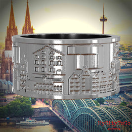 Silberner Ring mit Reliefs bekannter Sehenswürdigkeiten der Stadt Koeln. Den Hintergrund bildet eine Ansicht der Stadt Koeln.