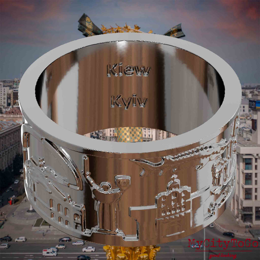 Versilberter Ring mit Reliefs bekannter Sehenswürdigkeiten der Stadt Kiew und einer Gravur des Stadtnamens auf der Innenseite. Den Hintergrund bildet eine Ansicht der Stadt Kiew.