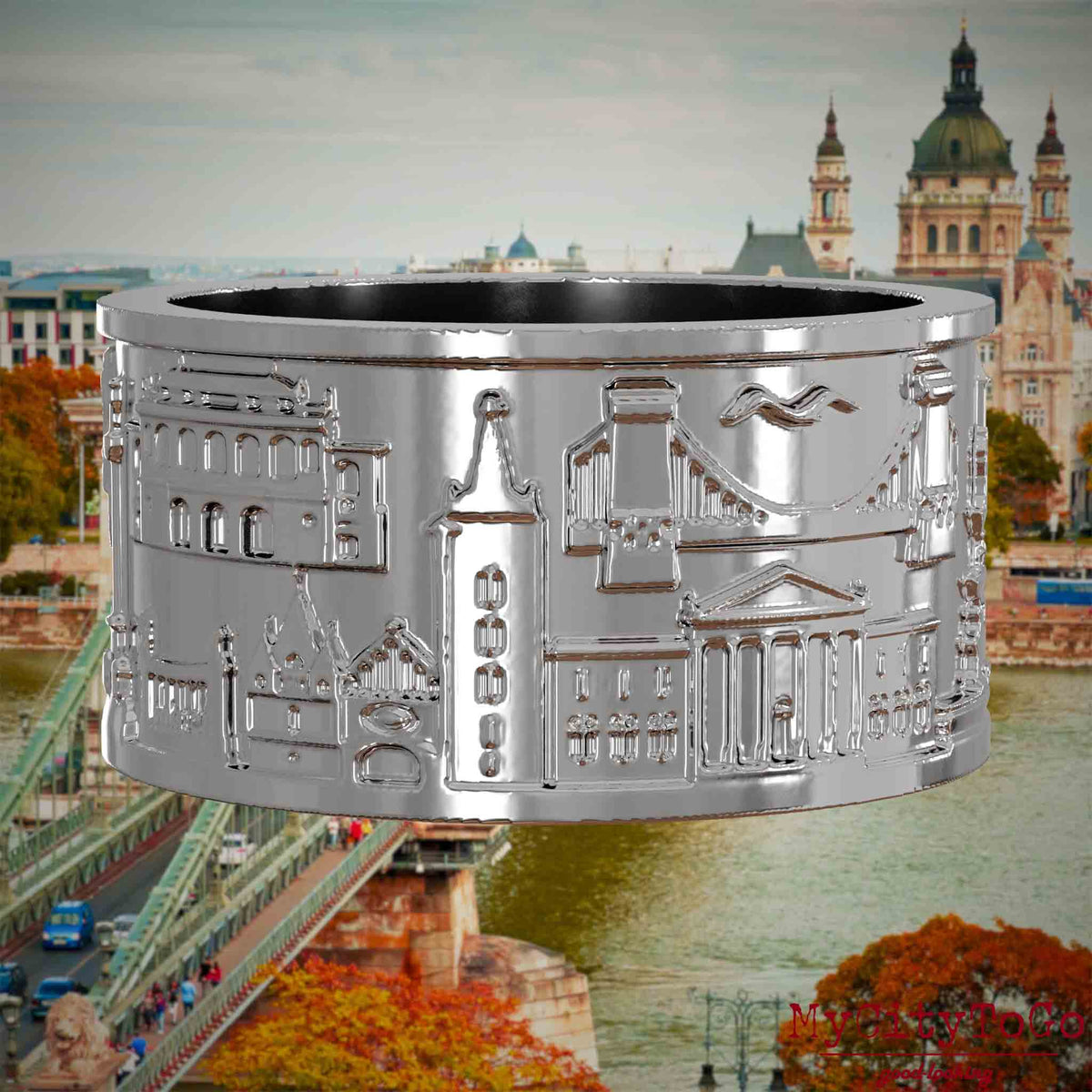 Silberner Ring mit Reliefs bekannter Sehenswürdigkeiten der Stadt Budapest. Den Hintergrund bildet eine Ansicht der Stadt Budapest.