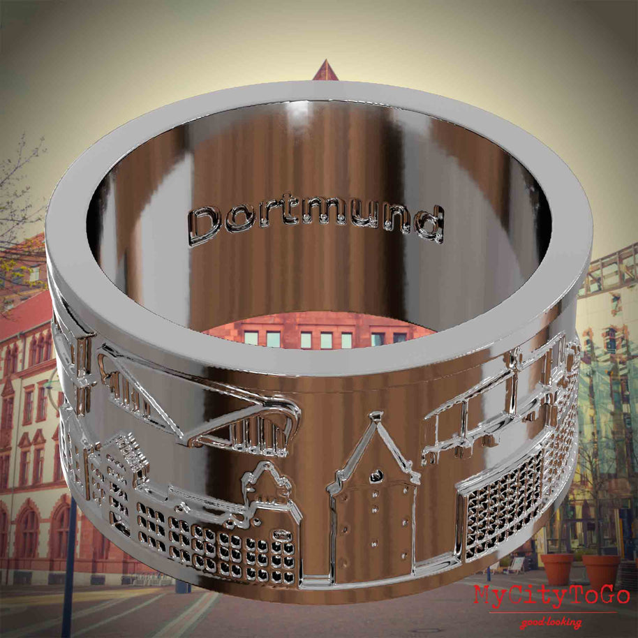 Versilberter Ring mit Reliefs bekannter Sehenswürdigkeiten der Stadt Dortmund und einer Gravur des Stadtnamens auf der Innenseite. Den Hintergrund bildet eine Ansicht der Stadt Dortmund.