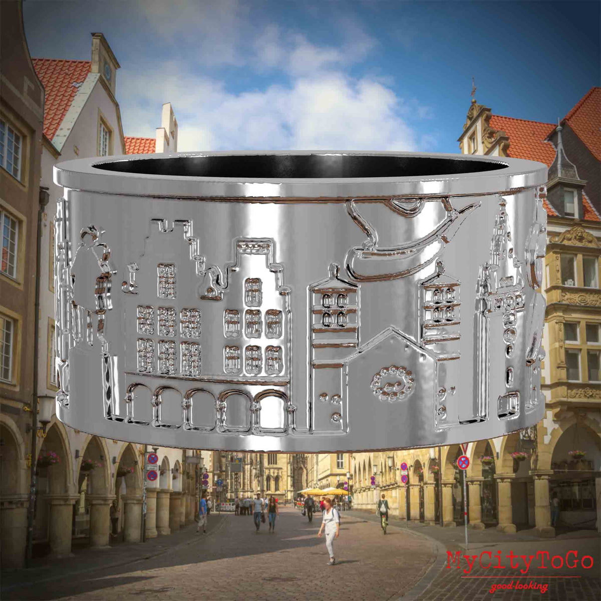 Silberner Ring mit Reliefs bekannter Sehenswürdigkeiten der Stadt Muenster. Den Hintergrund bildet eine Ansicht der Stadt Muenster.