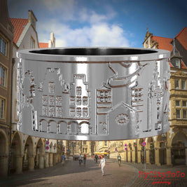Silberner Ring mit Reliefs bekannter Sehenswürdigkeiten der Stadt Muenster. Den Hintergrund bildet eine Ansicht der Stadt Muenster.