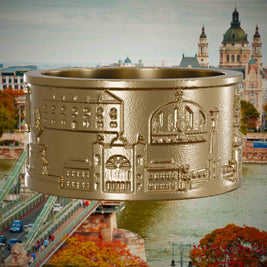 Ring aus vergoldetem Edelstahl mit Reliefs bekannter Sehenswürdigkeiten der Stadt Budapest. Den Hintergrund bildet eine Ansicht der Stadt Budapest.