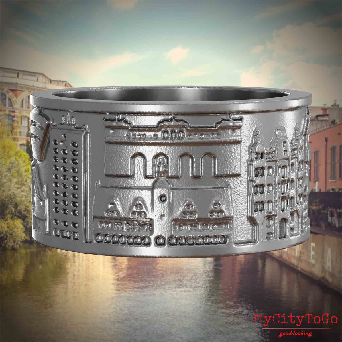 Ring aus Edelstahl mit Reliefs bekannter Sehenswürdigkeiten der Stadt Leipzig. Den Hintergrund bildet eine Ansicht der Stadt Leipzig.