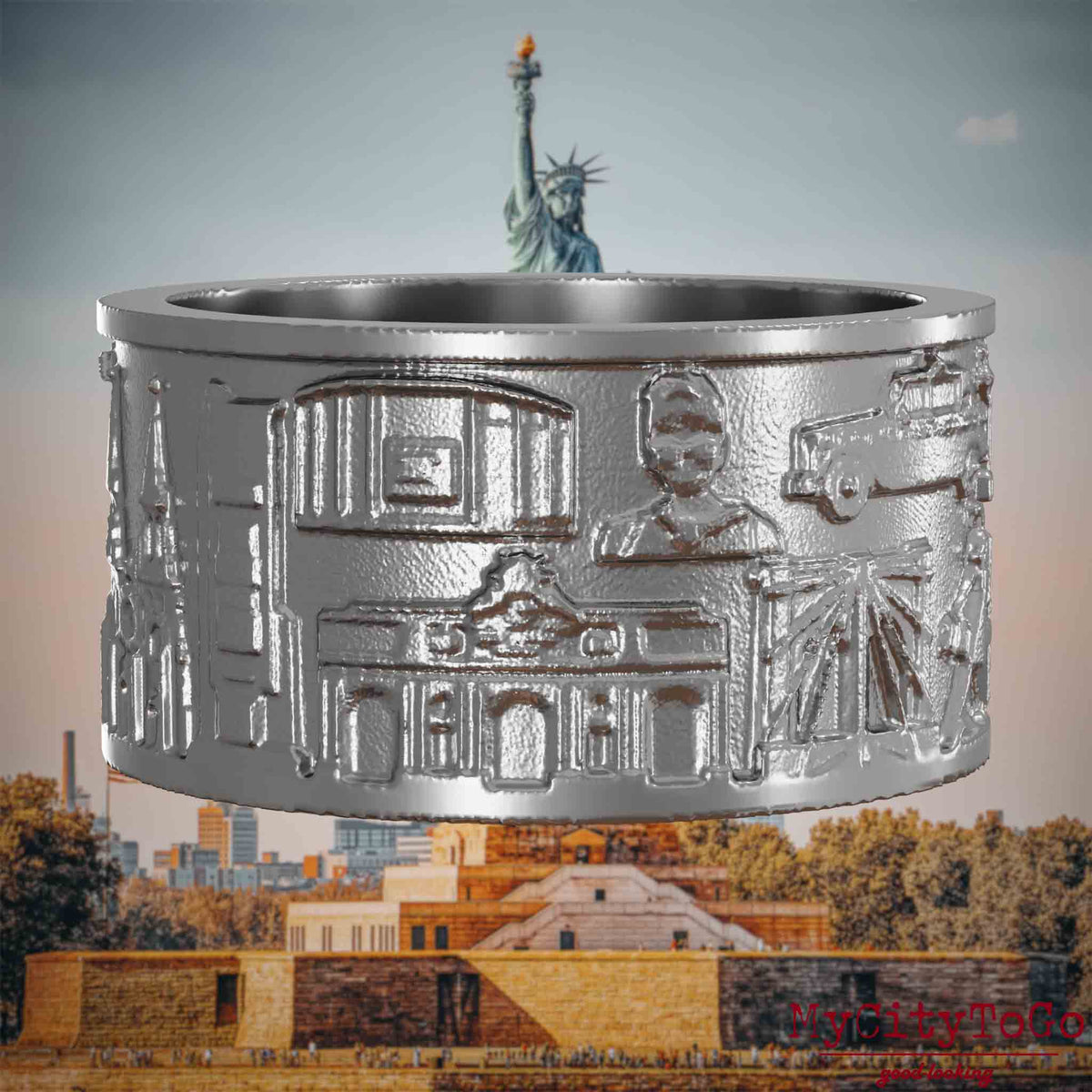 Ring aus Edelstahl mit Reliefs bekannter Sehenswürdigkeiten der Stadt New York. Den Hintergrund bildet eine Ansicht der Stadt New York.