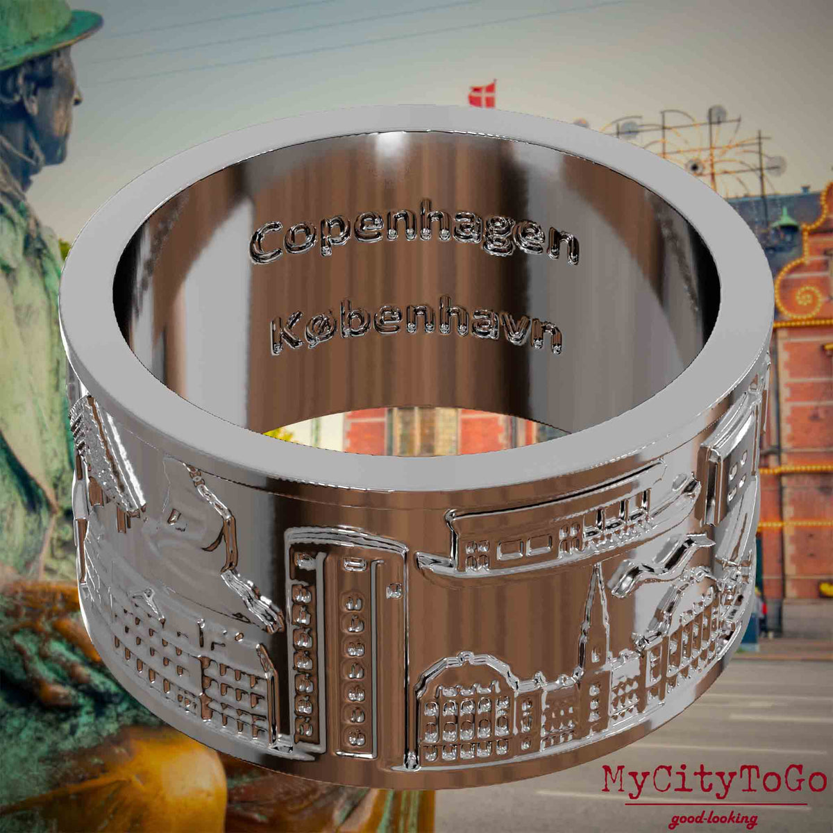 Versilberter Ring mit Reliefs bekannter Sehenswürdigkeiten der Stadt Kopenhagen und einer Gravur des Stadtnamens auf der Innenseite. Den Hintergrund bildet eine 
Ansicht der Stadt Kopenhagen.
