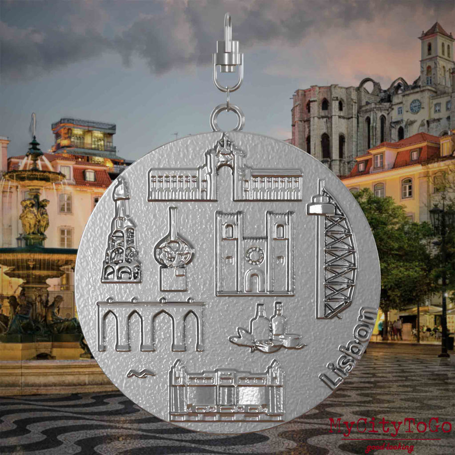 Halskette mit Drehwirbel und Rückseite eines Schmuckanhängers aus Edelstahl, auf dem Reliefs bekannter Sehenswürdigkeiten der Stadt Lissabon abgebildet sind. Den Hintergrund bildet eine Ansicht der Stadt Lissabon.
