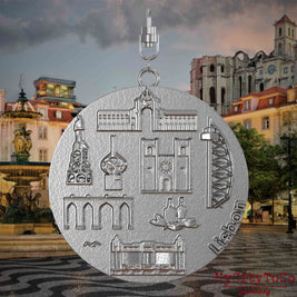 Halskette mit Drehwirbel und Rückseite eines Schmuckanhängers aus Edelstahl, auf dem Reliefs bekannter Sehenswürdigkeiten der Stadt Lissabon abgebildet sind. Den Hintergrund bildet eine Ansicht der Stadt Lissabon.
