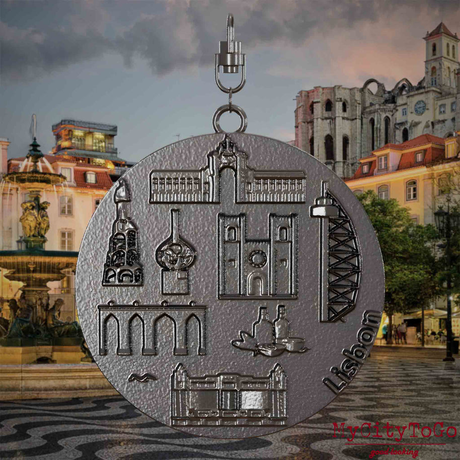 Halskette mit Drehwirbel und Rückseite eines Schmuckanhängers aus Titan, auf dem Reliefs bekannter Sehenswürdigkeiten der Stadt Lissabon abgebildet sind. Den Hintergrund bildet eine Ansicht der Stadt Lissabon.
