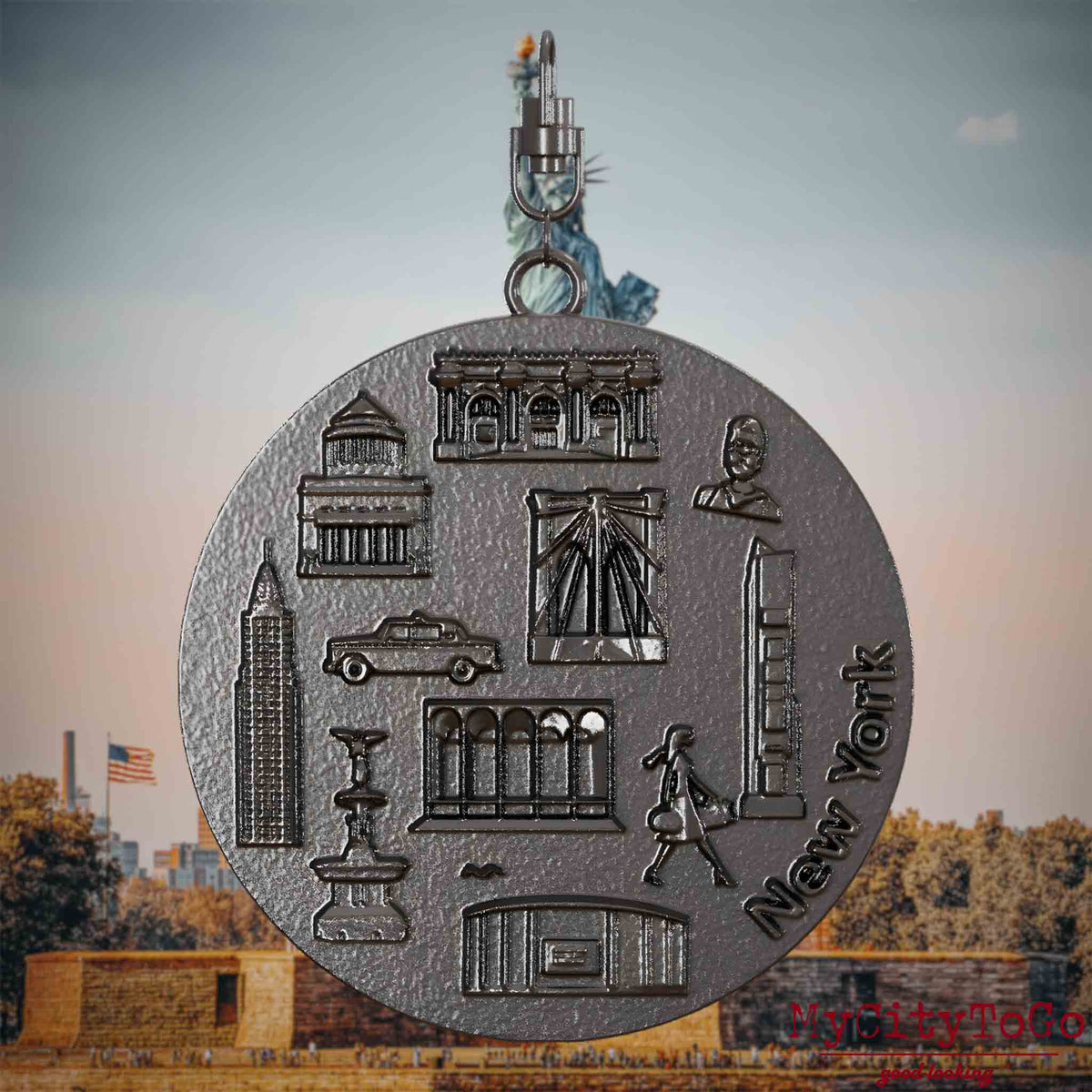 Halskette mit Drehwirbel und Rückseite eines Schmuckanhängers aus Titan, auf dem Reliefs bekannter Sehenswürdigkeiten der Stadt New York abgebildet sind. Den Hintergrund bildet eine Ansicht der Stadt New York.
