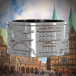 Silberner Ring mit Reliefs bekannter Sehenswürdigkeiten der Stadt Bremen. Den Hintergrund bildet eine Ansicht der Stadt Bremen.
