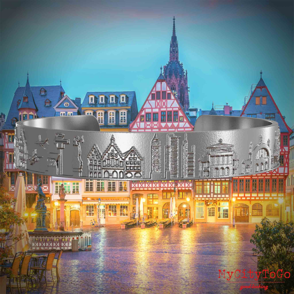Armreif aus Edelstahl mit Reliefs bekannter Sehenswürdigkeiten der Stadt Frankfurt. Den Hintergrund bildet eine Ansicht der Stadt Frankfurt.