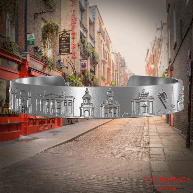 Armreif aus Edelstahl mit Reliefs bekannter Sehenswürdigkeiten der  Stadt Dublin. Den Hintergrund bildet eine Ansicht der Stadt Dublin.