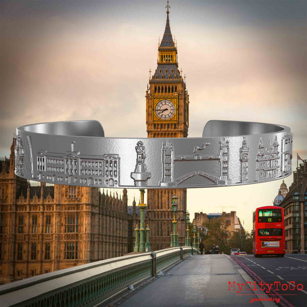 Amreif aus Edelstahl mit Reliefs bekannter Sehenswürdigkeiten der Stadt London. Den Hintergrund bildet eine Ansicht der Stadt London.