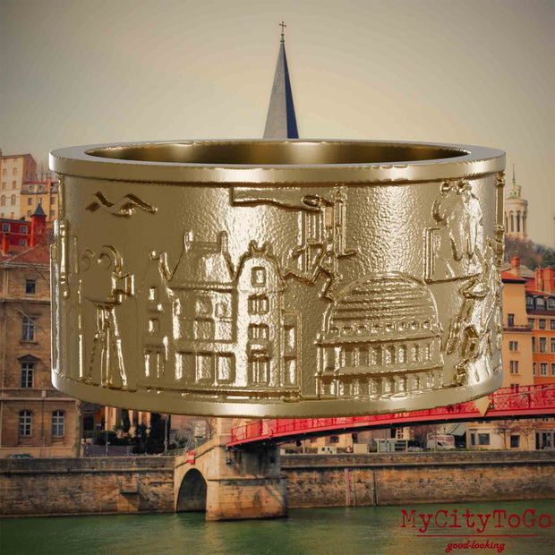 Ring aus vergoldetem Edelstahl mit Reliefs bekannter Sehenswürdigkeiten der Stadt Lyon. Den Hintergrund bildet eine Ansicht der Stadt Lyon.