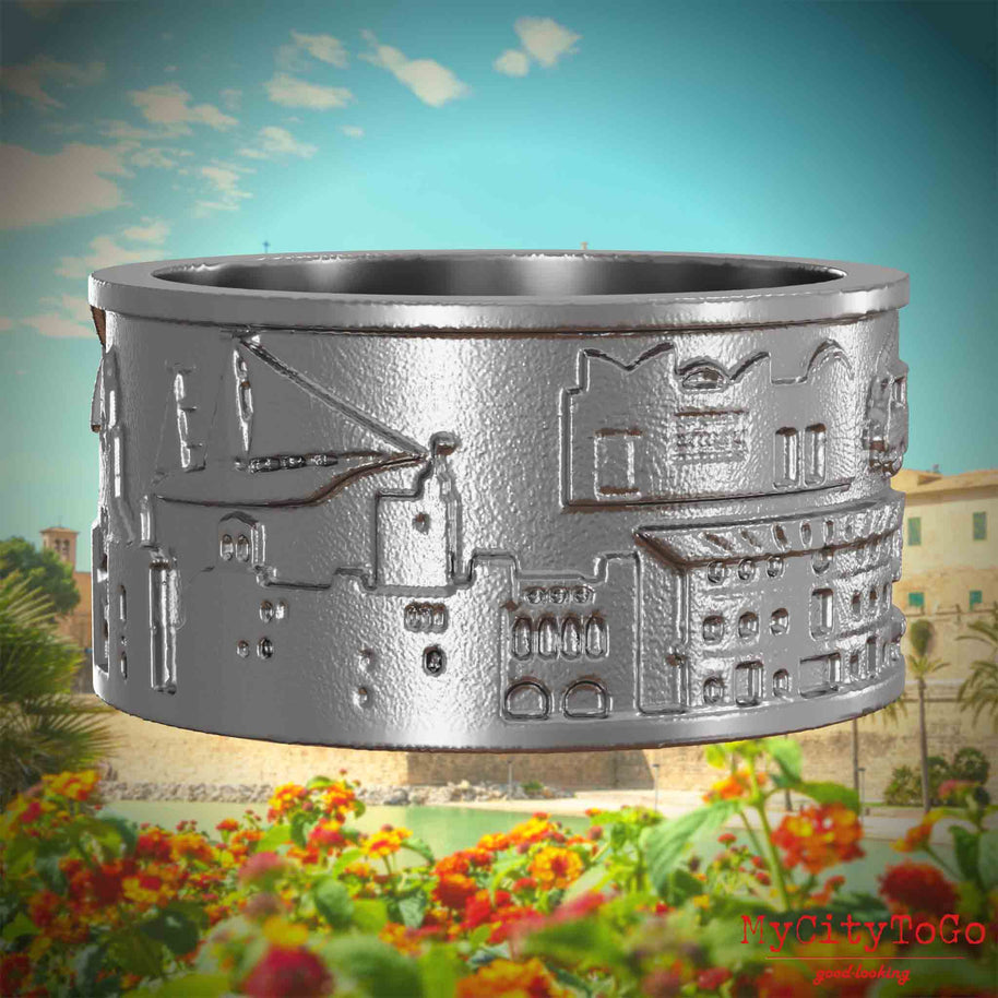 Ring aus Edelstahl mit Reliefs bekannter Sehenswürdigkeiten der Stadt Palma de Mallorca. Den Hintergrund bildet eine Ansicht der Stadt Palma de Mallorca.