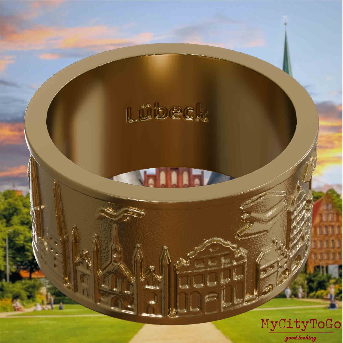 Ring aus vergoldetem Edelstahl mit Reliefs bekannter Sehenswürdigkeiten der Stadt Luebeck und einer Gravur des Stadtnamens auf der Innenseite. Den Hintergrund bildet eine Ansicht der Stadt Luebeck.