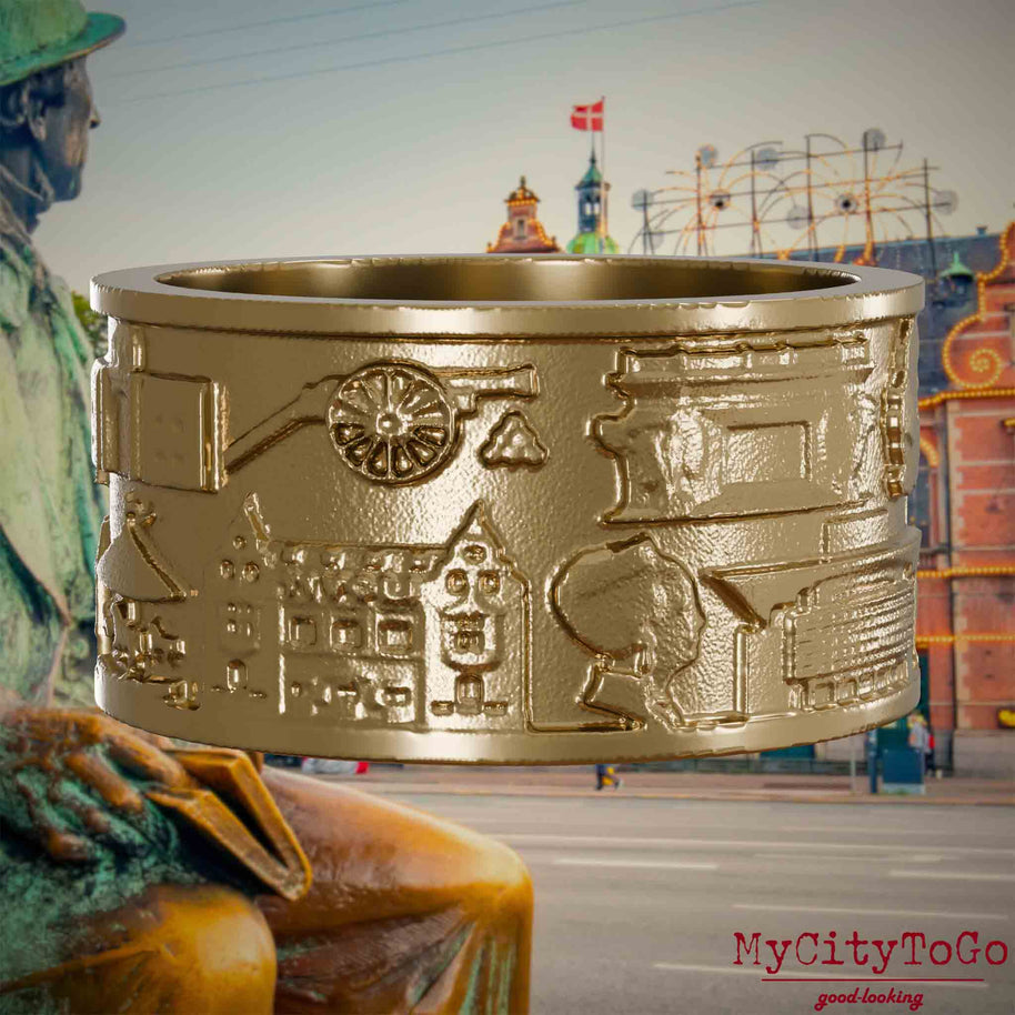 Ring aus vergoldetem Edelstahl mit Reliefs bekannter Sehenswürdigkeiten der Stadt Kopenhagen. Den Hintergrund bildet eine 
Ansicht der Stadt Kopenhagen.
