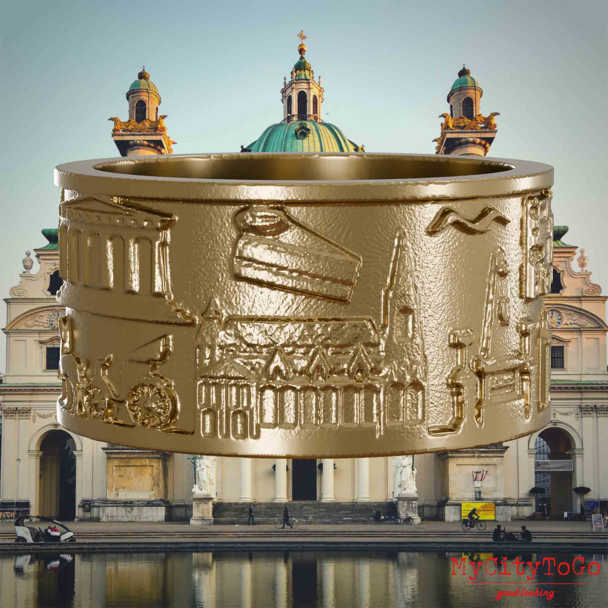 Ring aus vergoldetem Edelstahl mit Reliefs bekannter Sehenswürdigkeiten der Stadt Wien. Den Hintergrund bildet eine Ansicht der Stadt Wien.