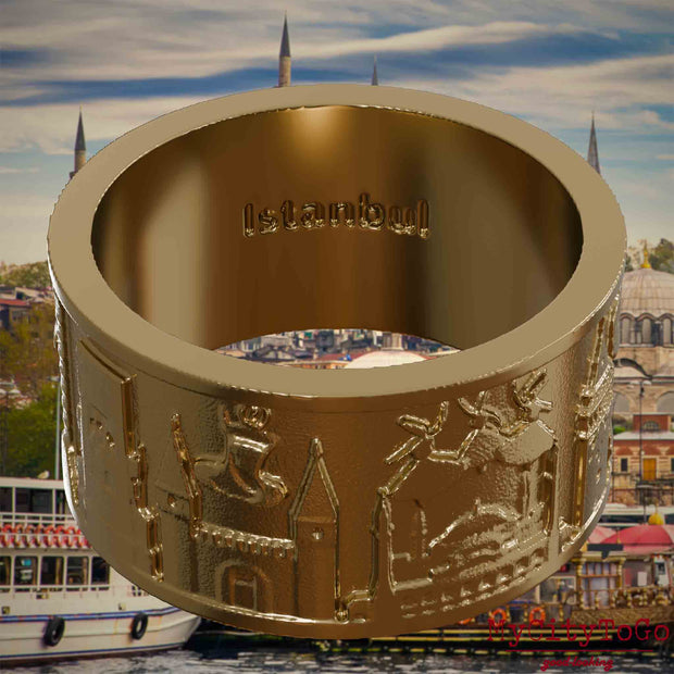 Ring aus vergoldetem Edelstahl mit Reliefs bekannter Sehenswürdigkeiten der Stadt Istanbul und einer Gravur des Stadtnamens auf der Innenseite. Den Hintergrund bildet eine Ansicht der Satdt Istanbul.