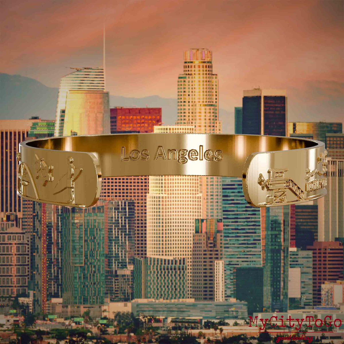 Innenseite eines vergoldeten Armreifs mit Reliefs bekannter Sehenswürdigkeiten der Stadt Los Angeles und einer Gravur des Stadtnamens. Den Hintergrund bildet eine Ansicht der Stadt Los Angeles.