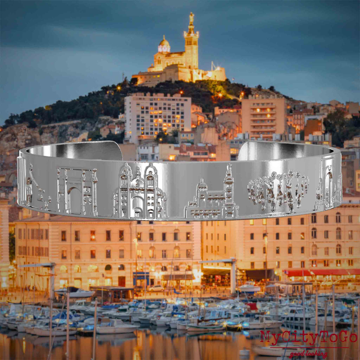 Versilberter Armreif mit Reliefs bekannter Sehenswürdigkeiten der Stadt Marseille. Den Hintergrund bildet eine Ansicht der Stadt Marseille.