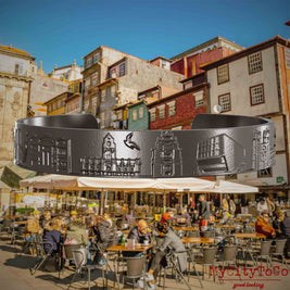 Armreif aus Titan mit Reliefs bekannter Sehenswürdigkeiten der Stadt Porto. Den Hintergrund bildet eine Ansicht der Stadt Porto.