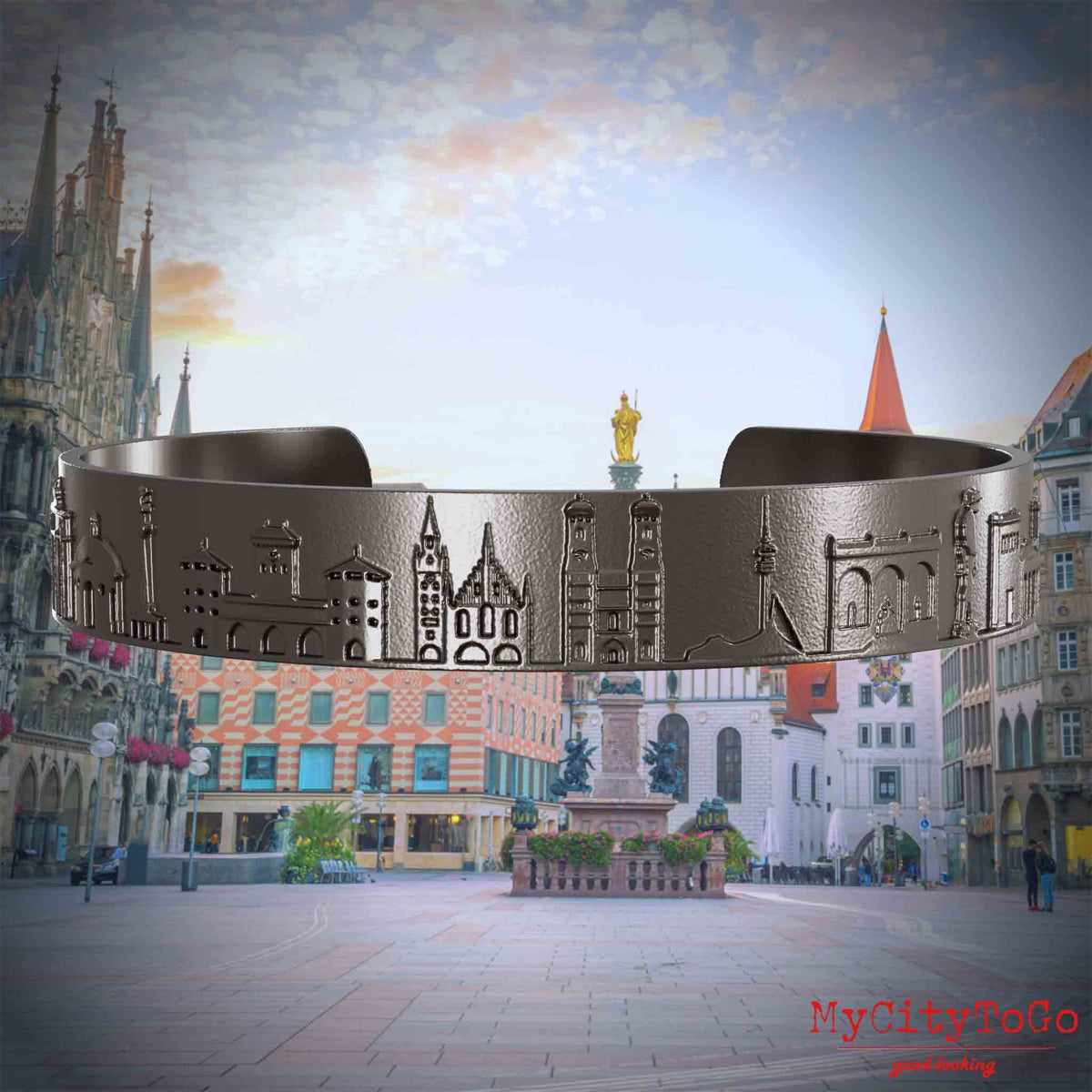 Armreif aus Titan mit Reliefs bekannter Sehenswürdigkeiten der Stadt München. Den Hintergrund bildet eine Ansicht der Stadt Muenchen.