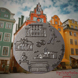 Halskette mit Drehwirbel und Vorderseite eines Schmuckanhängers aus Titan, auf dem Reliefs bekannter Sehenswürdigkeiten der Stadt Stockholm abgebildet sind. Den Hintergrund bildet eine Ansicht der Stadt Stockholm.
