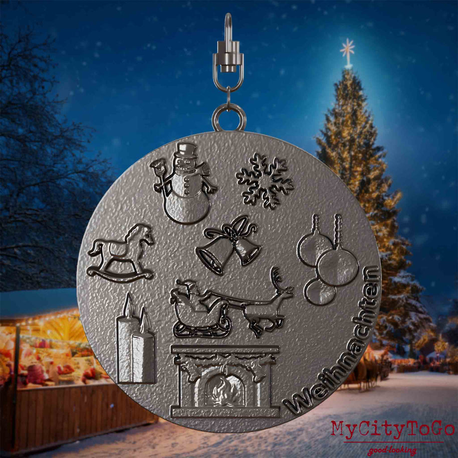 Halskette mit Drehwirbel und Vorderseite eines Schmuckanhängers aus Titan, auf dem Reliefs bekannter Weihnachst- und Wintermotive abgebildet sind. Den Hintergrund bildet ein naechtliches Weihnachtsmotiv.

