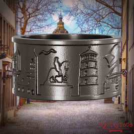 Ring aus Titan mit Reliefs bekannter Sehenswürdigkeiten der Stadt Duesseldorf. Den Hintergrund bildet eine Ansicht der Stadt Duesseldorf.