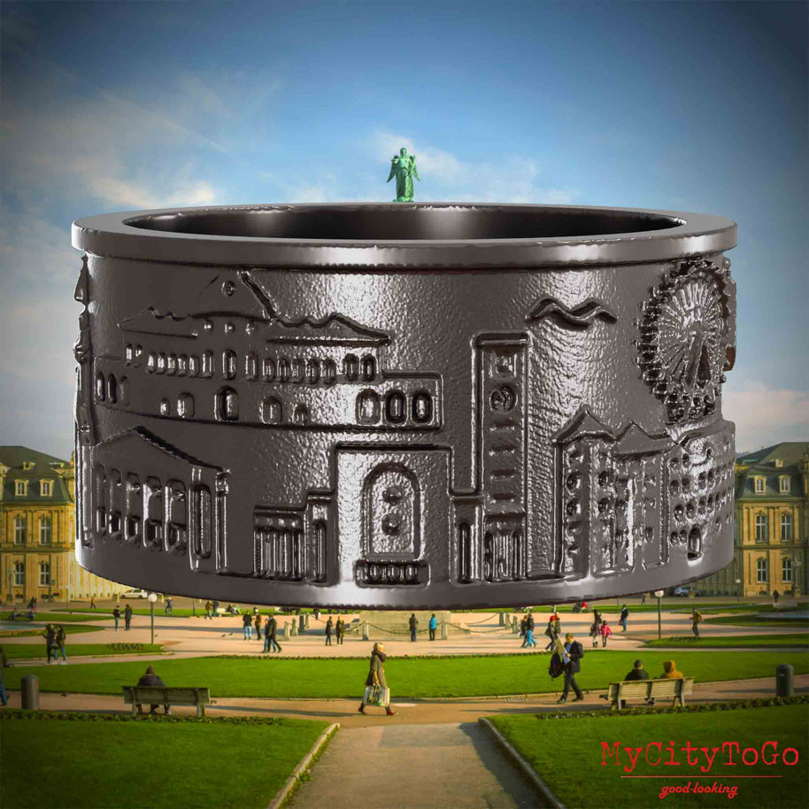 Ring aus Titan mit Reliefs bekannter Sehenswürdigkeiten der Stadt Stuttgart. Den Hintergrund bildet eine Ansicht der Stadt Stuttgart.