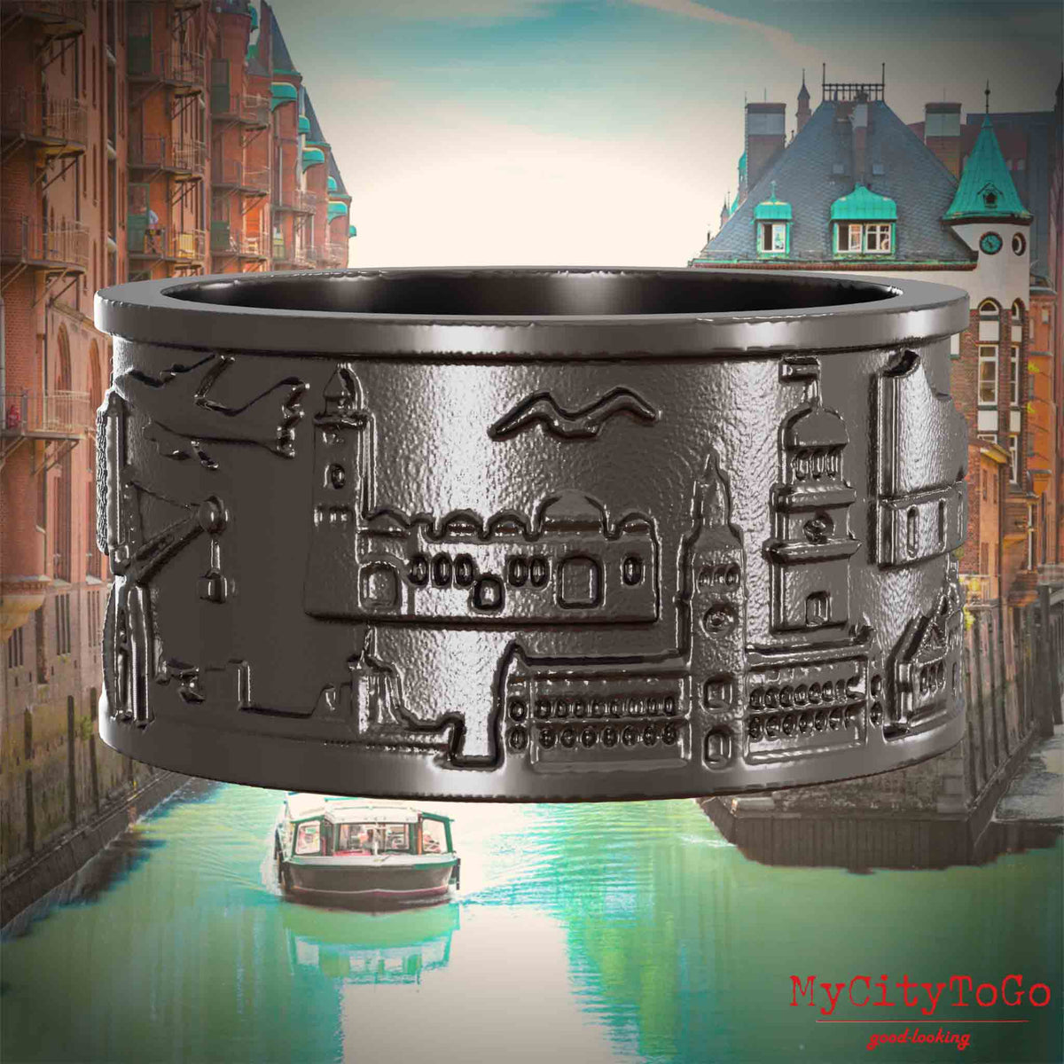 Ring aus Titan mit Reliefs bekannter Sehenswürdigkeiten der Stadt Hamburg. Den Hintergrund bildet eine Ansicht der Stadt Hamburg.