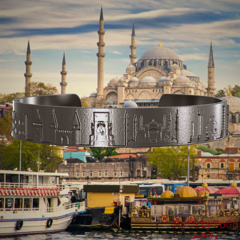 Armreif aus Titan mit Reliefs bekannter Sehenswürdigkeiten der Stadt Istanbul. Den Hintergrund bildet eine Ansicht der Satdt Istanbul.