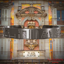 Armreif aus Titan mit Reliefs bekannter Sehenswürdigkeiten der Stadt Madrid. Den Hintergrund bildet eine Ansicht der Stadt Madrid.