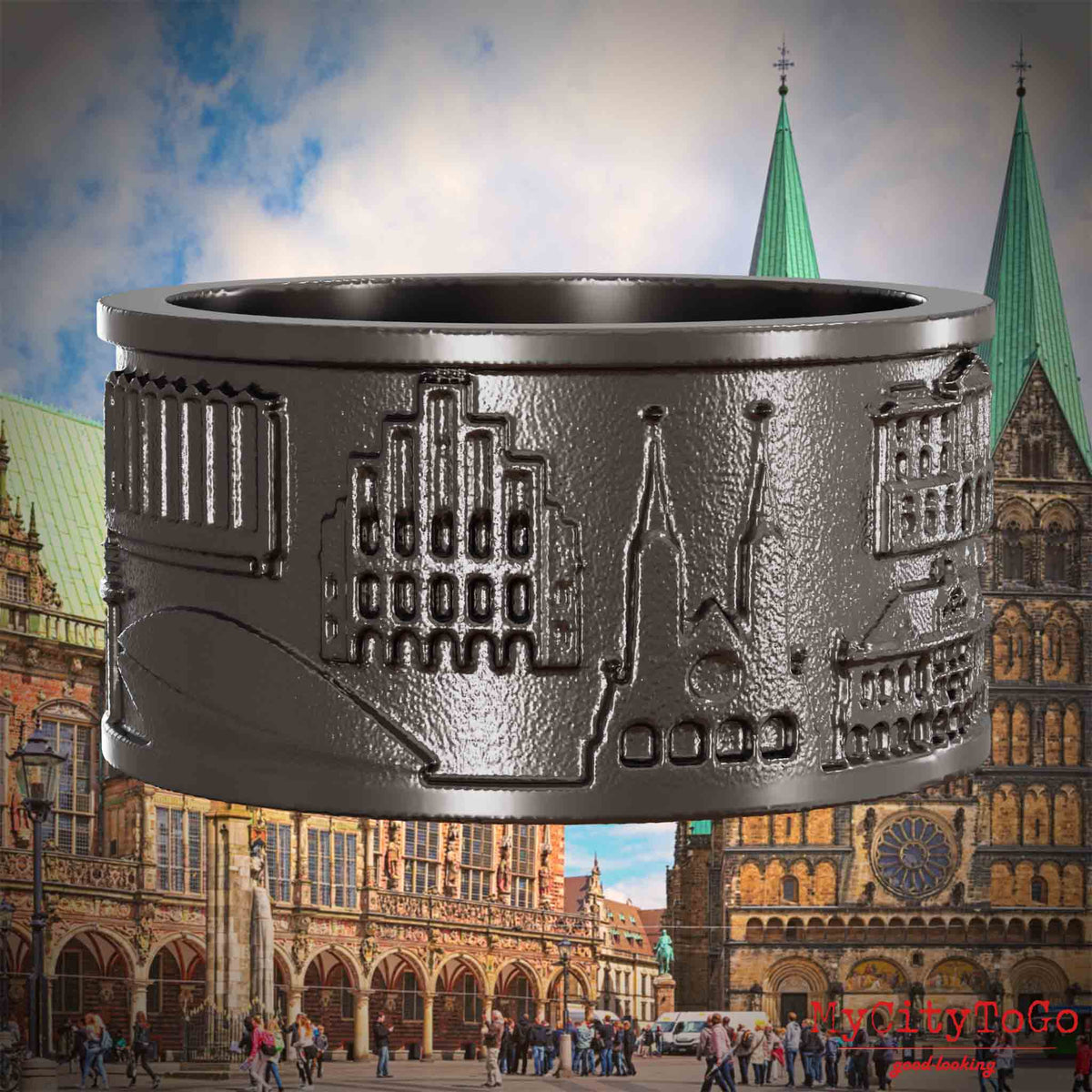 Ring aus Titan mit Reliefs bekannter Sehenswürdigkeiten der Stadt Bremen. Den Hintergrund bildet eine Ansicht der Stadt Bremen.