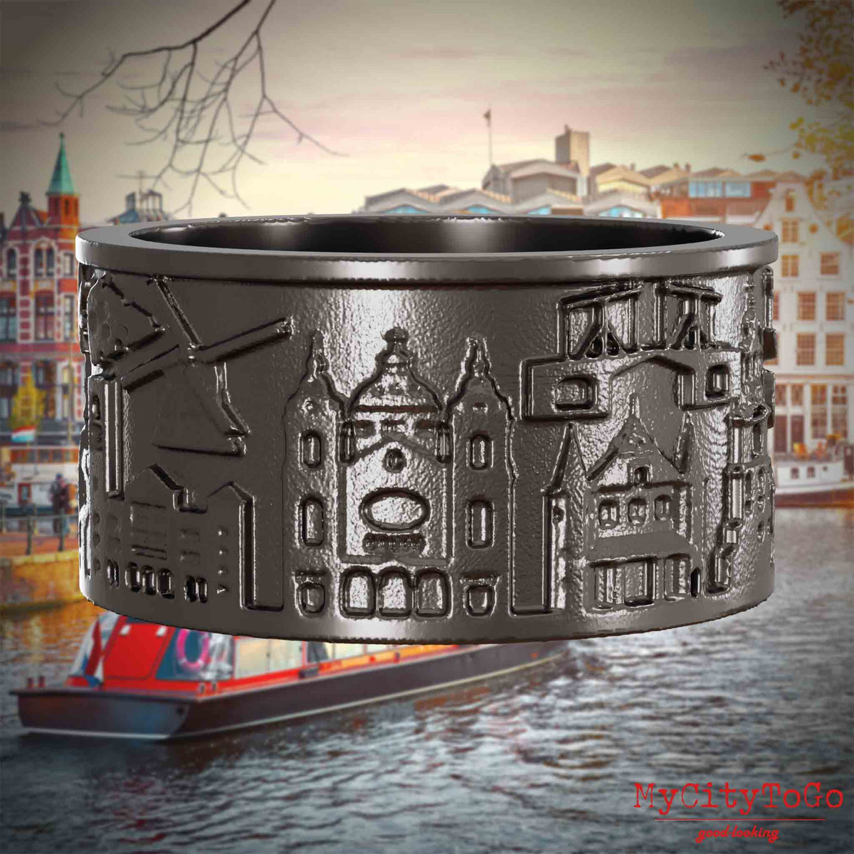 Ring aus Titan mit Reliefs bekannter Sehenswürdigkeiten der Stadt Amsterdam. Den Hintergrund bildet eine Ansicht der Stadt Amsterdam.
