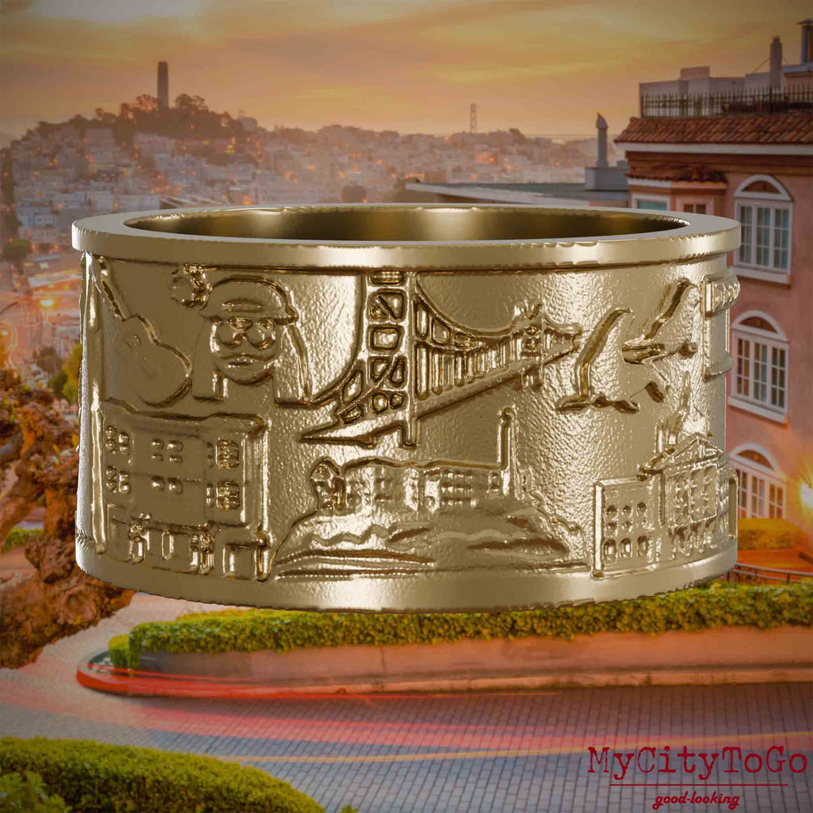 Ring aus vergoldetem Edelstahl mit Reliefs bekannter Sehenswürdigkeiten der Stadt San Francisco. Den Hintergrund bildet eine Ansicht der Stadt San Francisco.