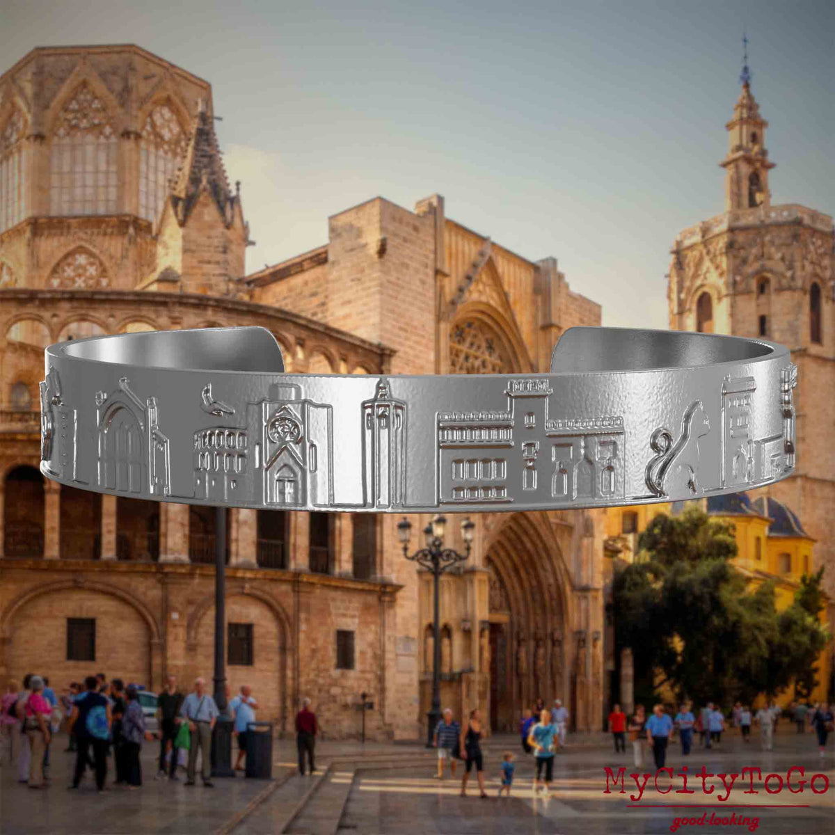 Armreif aus Edelstahl mit Reliefs bekannter Sehenswürdigkeiten der Stadt Valencia. Den Hintergrund bildet eine Ansicht der Stadt Valencia.