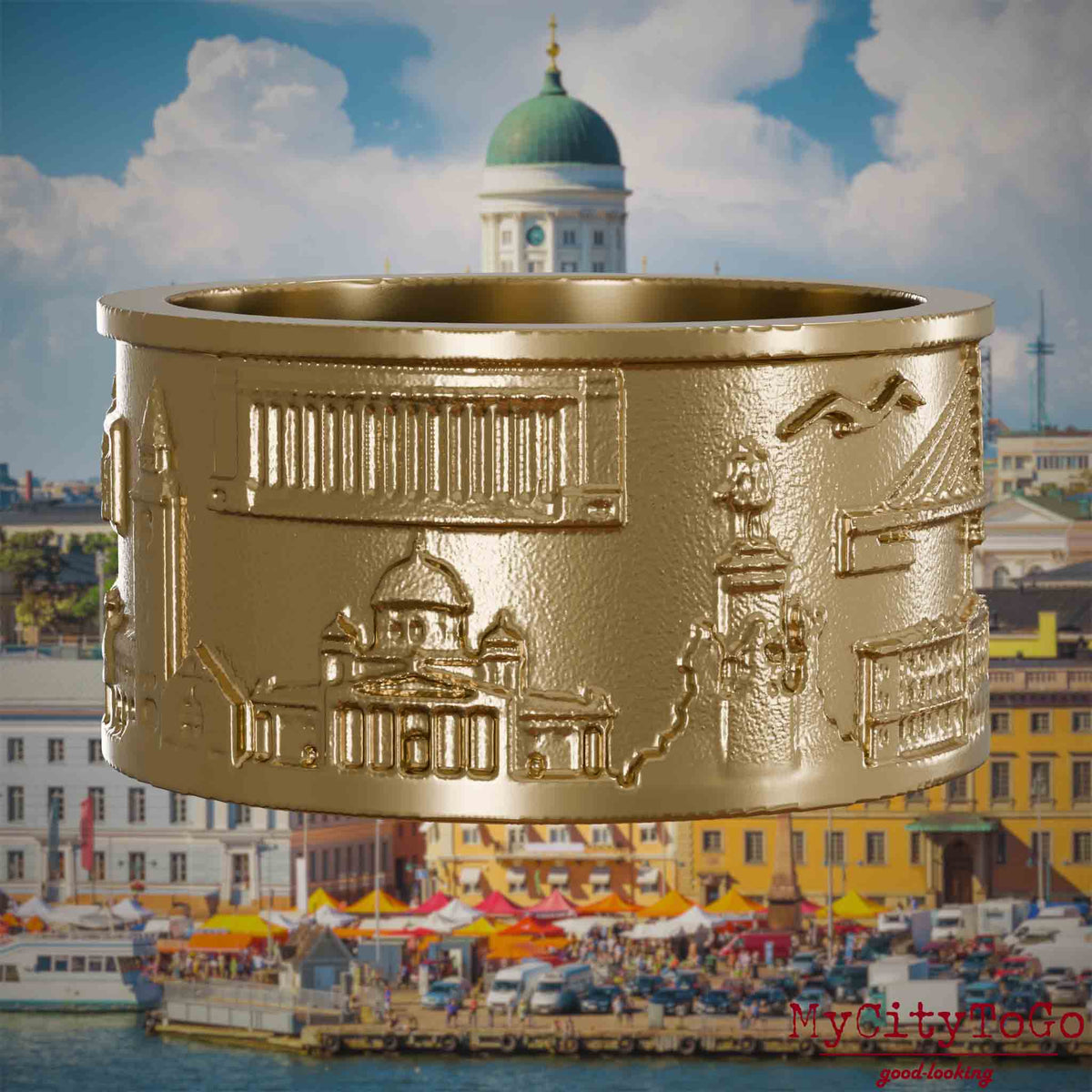 Ring aus vergoldetem Edelstahl mit Reliefs bekannter Sehenswürdigkeiten der Stadt Helsinki. Den Hintergrund bildet eine Ansicht der Stadt Helsinki.