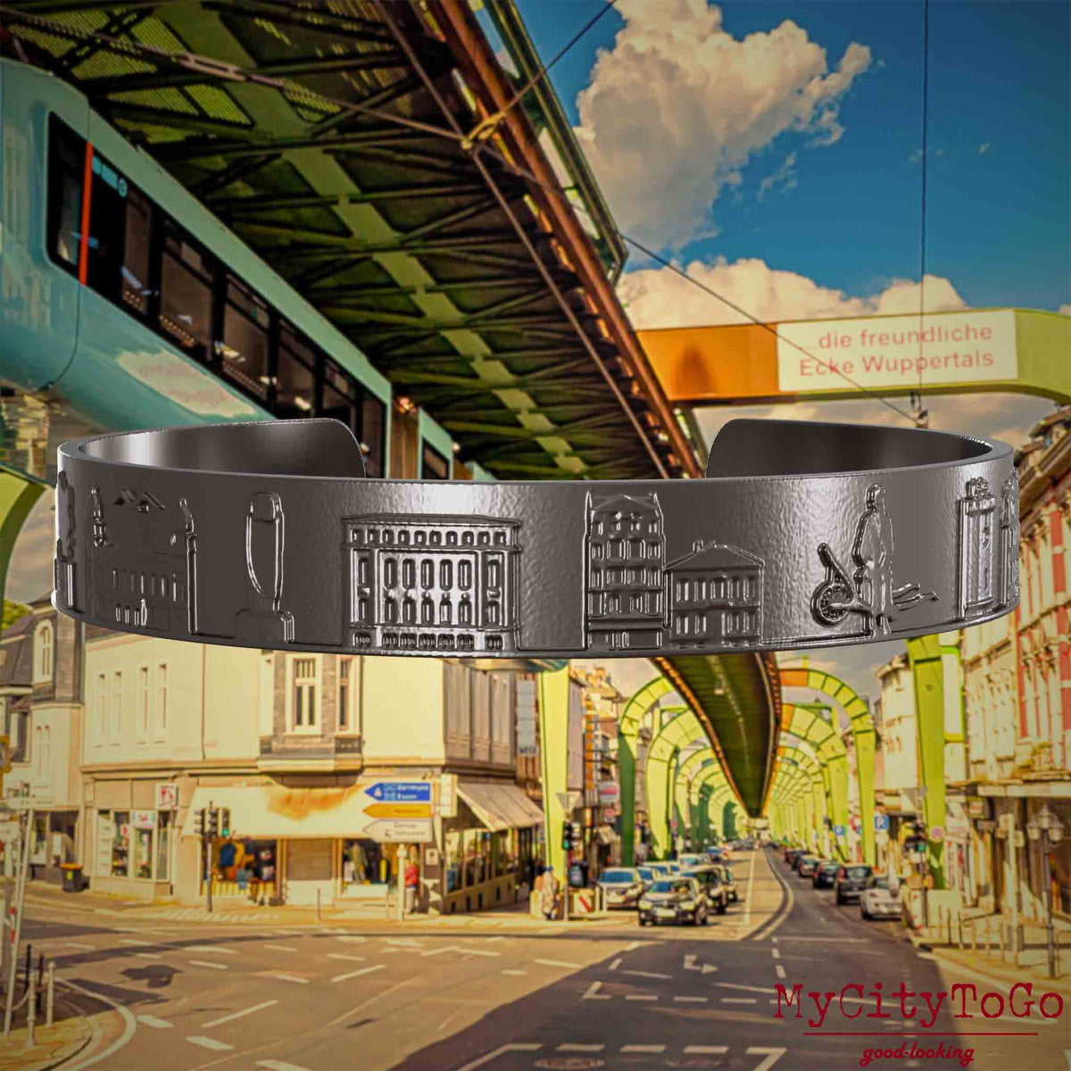 Armreif aus Titan mit Reliefs bekannter Sehenswürdigkeiten der Stadt Wuppertal. Den Hintergrund bildet eine Ansicht  der Stadt Wuppertal.