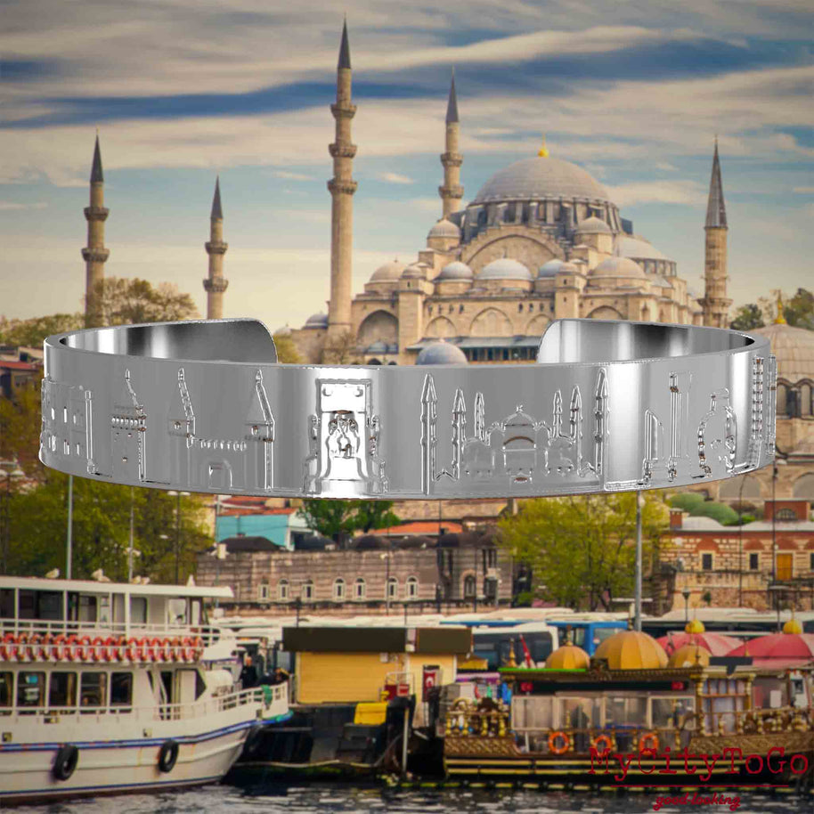 Versilberter Armreif mit Reliefs bekannter Sehenswürdigkeiten der Stadt Istanbul. Den Hintergrund bildet eine Ansicht der Satdt Istanbul.