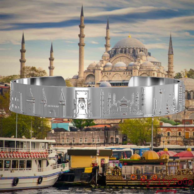 Versilberter Armreif mit Reliefs bekannter Sehenswürdigkeiten der Stadt Istanbul. Den Hintergrund bildet eine Ansicht der Satdt Istanbul.