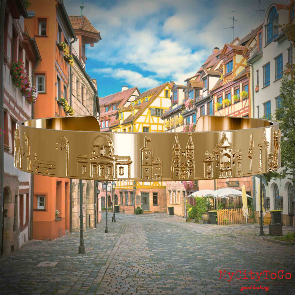 Vergoldeter Armreif mit Reliefs bekannter Sehenswürdigkeiten der Stadt Nürnberg. Den Hintergrund bildet eine Ansicht der Stadt  Nuernberg.