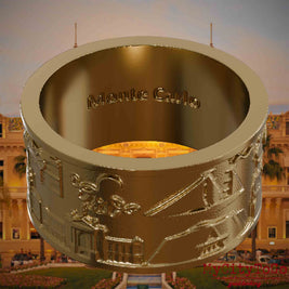 Ring aus vergoldetem Edelstahl mit Reliefs bekannter Sehenswürdigkeiten der Stadt Monte Carlo und einer Gravur des Stadtnamens auf der Innenseite. Den Hintergrund bildet eine Ansicht der Stadt Monte Carlo.