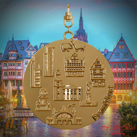 Halskette mit Drehwirbel und Vorderseite eines vergoldeten Schmuckanhängers, auf dem Reliefs bekannter Sehenswürdigkeiten der Stadt Frankfurt abgebildet sind. Den Hintergrund bildet eine Ansicht der Stadt Frankfurt.