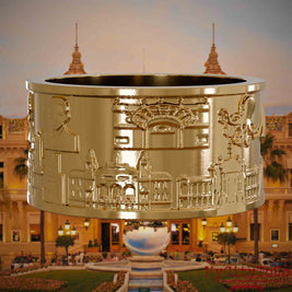 Vergoldeter Ring mit Reliefs bekannter Sehenswürdigkeiten der Stadt Monte Carlo. Den Hintergrund bildet eine Ansicht der Stadt Monte Carlo.